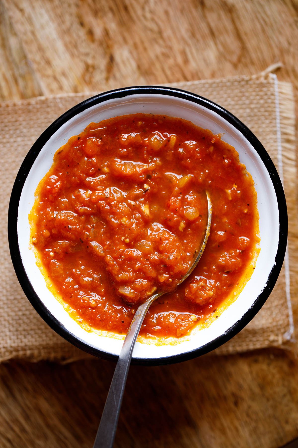 Silver spoon in a bowlful of homemade marinara sauce.
