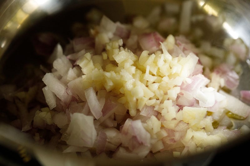 Chopped raw onions and minced garlic added to skillet.