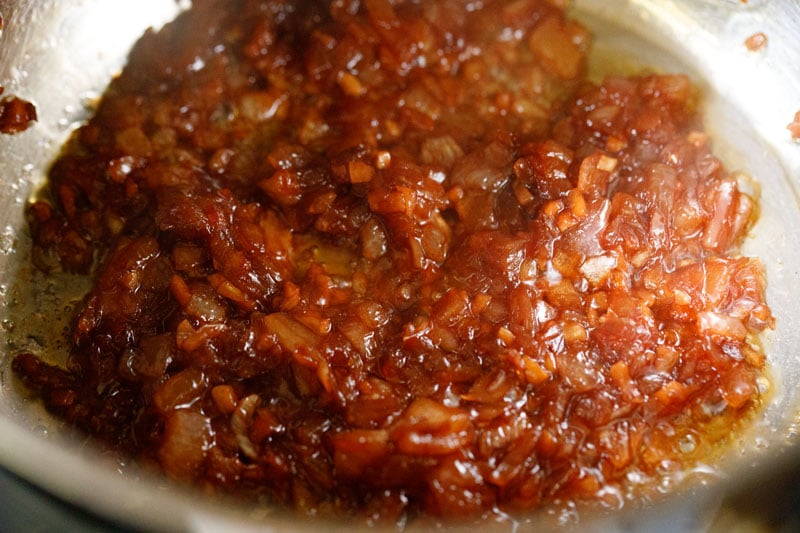 Deeply caramelized onions and garlic after liquid from wine has evaporated - the color is rather dark golden red.