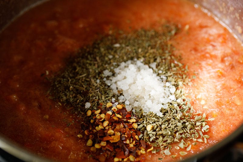 Spices and salt added to pot with crushed tomatoes.