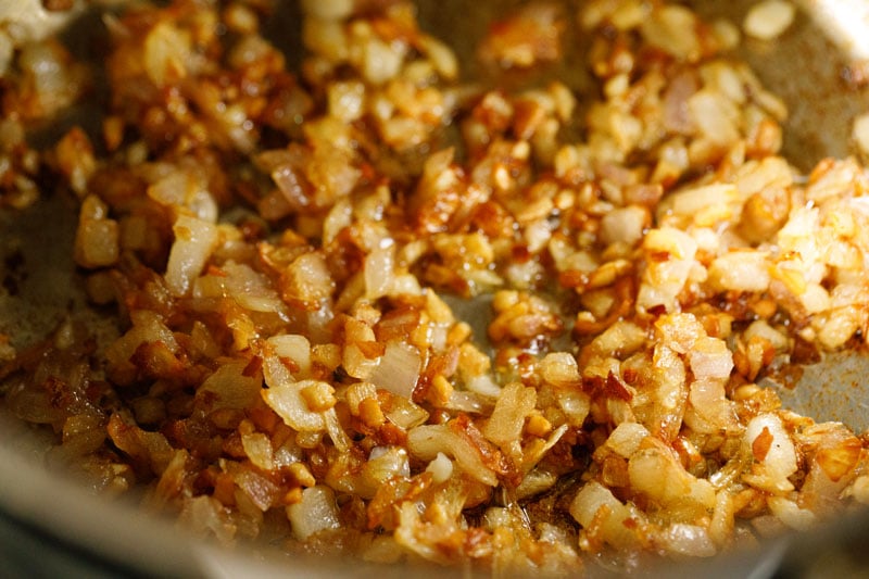Caramelized onions and garlic with deep golden hues in the skillet.