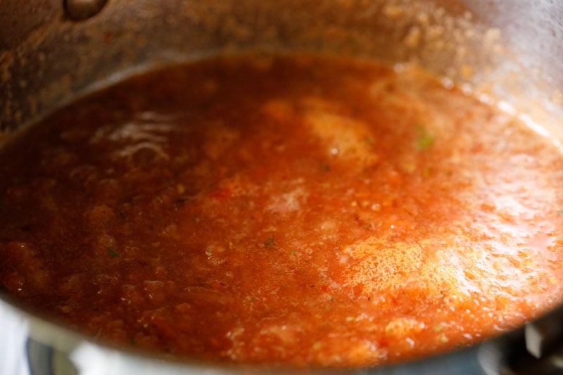 All ingredients for marinara sauce stirred together and simmering in the skillet.