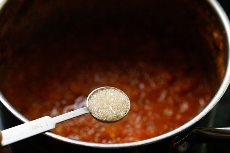 Sugar added to marinara in skillet off the heat to balance the acidity.