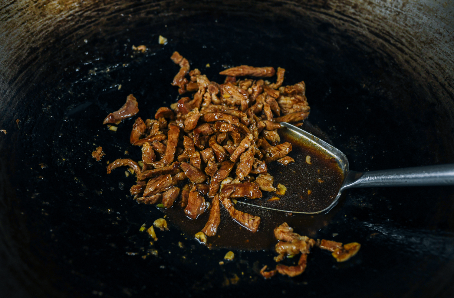 Stir-fried pork strips with sauce in wok