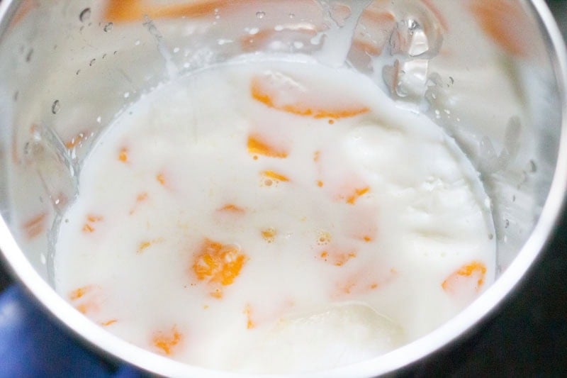 Mango kulfi ingredients in a blender.