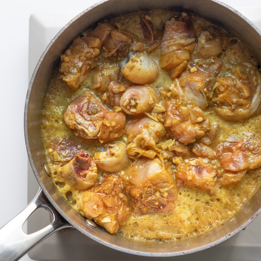 Adding liquid for Vietnamese braised turmeric chicken (Gà Kho Nghệ)