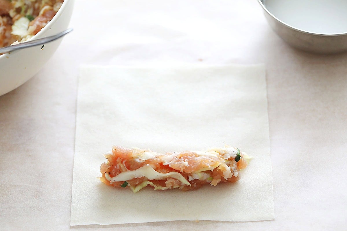 Lumpia filling at the bottom corner of a spring roll wrapper.