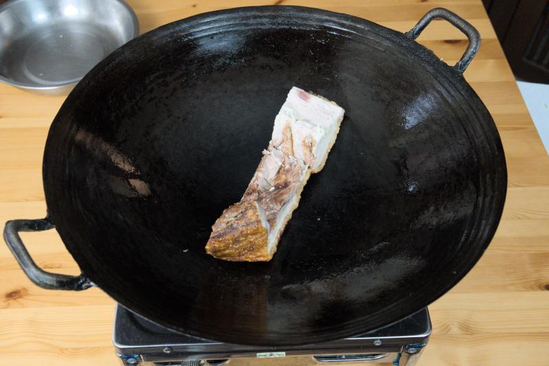 Sear the roast pork over medium heat until it becomes warm and fragrant again.