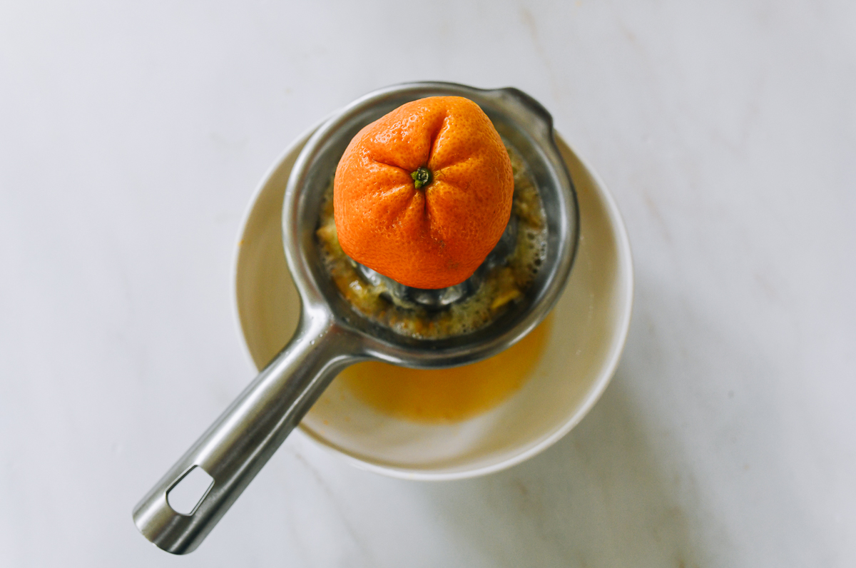Using citrus juicer to juice a clementine